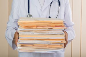 Doctor holding stack of paperwork