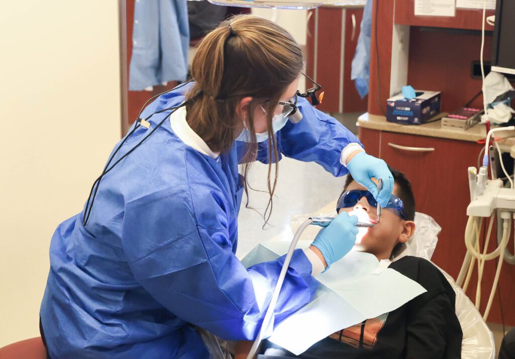 Student provides oral health screening at Back to School Brush-Up™