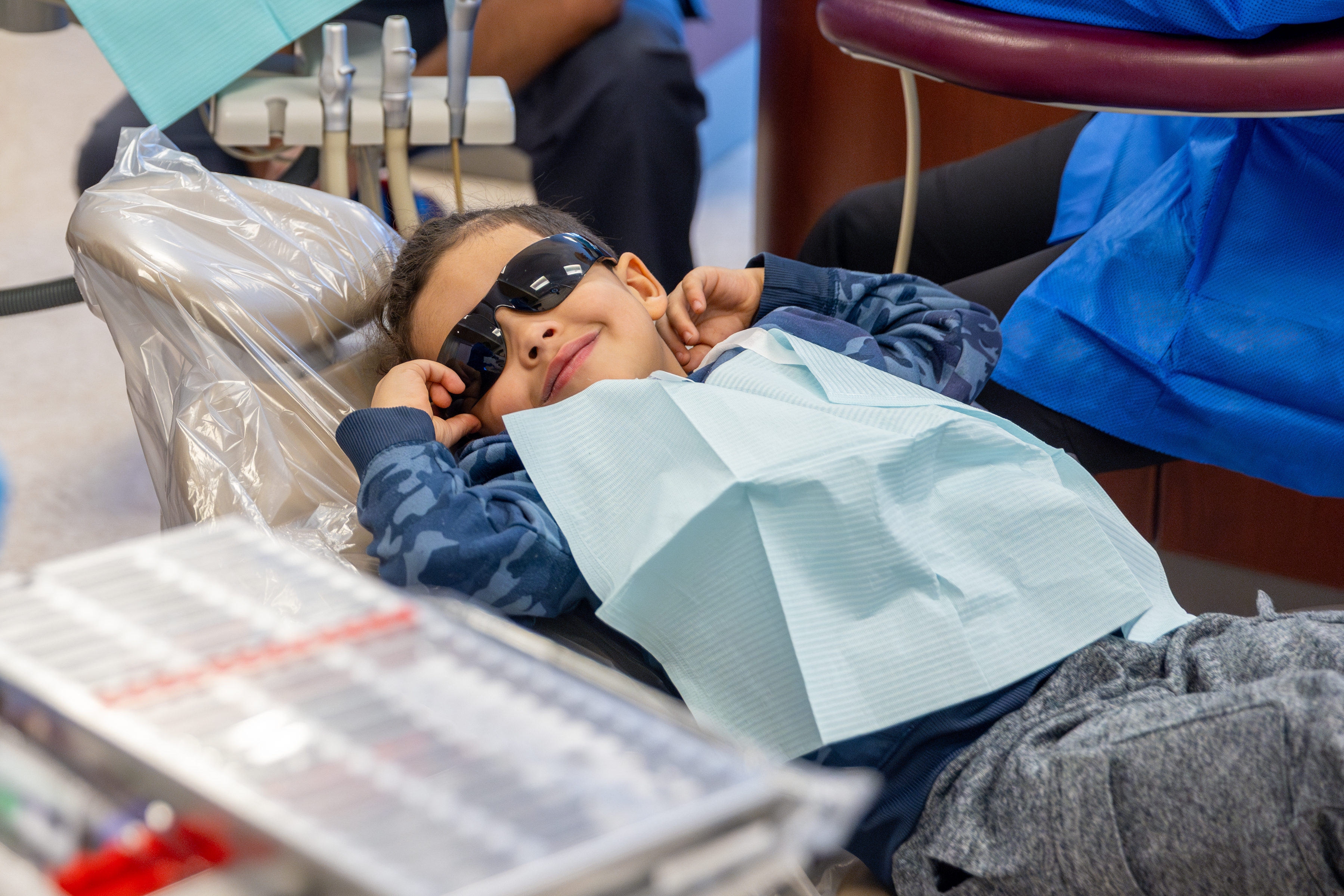 Young boy smiles broadly during oral health screening at Roseman's annual Give Kids a Smile event.