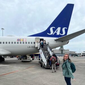 Dr. Kimberly Veltman smiles for a photo on the airport runway before boarding a Scandinavian Airways flight.