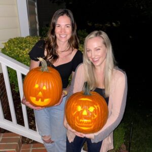 Dr. Kimberly Veltman and a friend show off one smiling and one skull-shaped pumpkin carving.