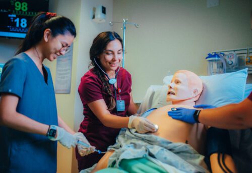 nursing students practicing on a mannequin