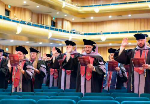 DMD graduates taking the Dentists' Pledge at Hooding Ceremony